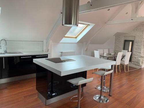a kitchen and dining room with a white table and chairs at LOFT face à la ville Close Concarneau in Concarneau