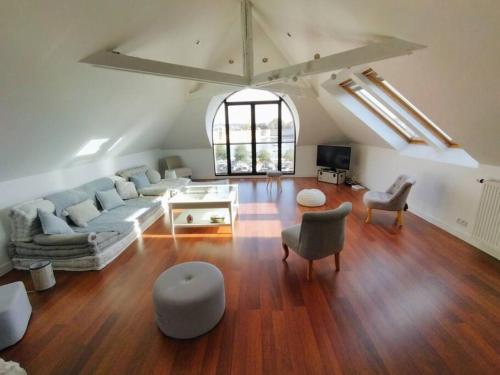 a large living room with a couch and chairs at LOFT face à la ville Close Concarneau in Concarneau