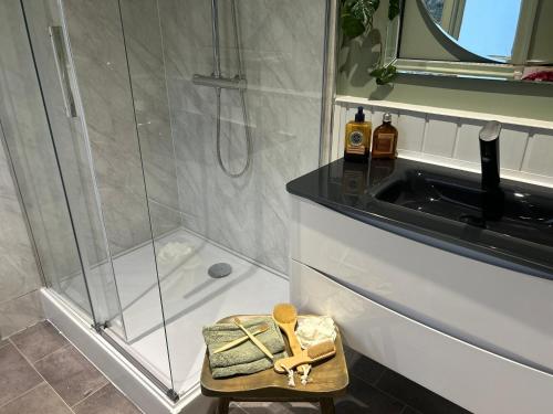 a bathroom with a shower and a stool with a sink at Park View is a beautiful whole entire house close to town centre, sleeps 8 in 4 rooms, 2 doubles and 4 single beds with 2 bathrooms, available for holidays, insurance stays, trades people, contractors, pets welcome in Wisbech