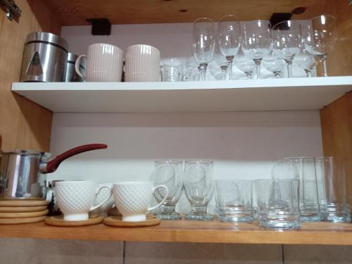 a shelf with glasses and dishes on it at Simic Apartmani Tara in Kaludjerske Bare