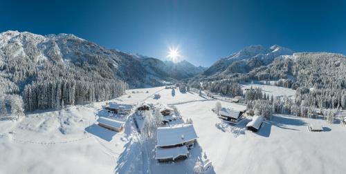 a snow covered mountain with the sun in the sky at Birgsau in Oberstdorf