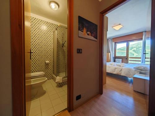 uma casa de banho com um WC, um lavatório e um quarto em Hostdomus - Color Apartment em Sestriere