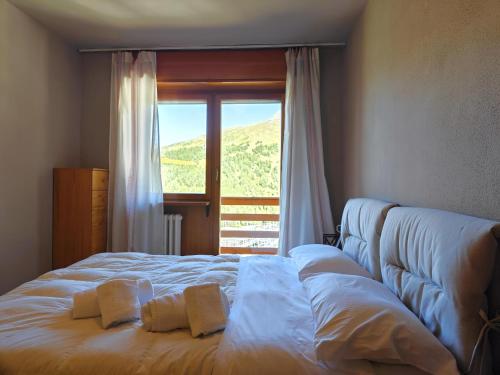 um quarto com uma cama grande e uma janela em Hostdomus - Color Apartment em Sestriere