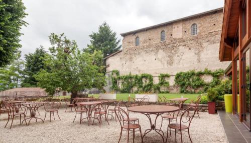 a group of tables and chairs in front of a building at Domaine Le Prieuré in Chaumont-le-Bourg