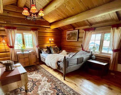a bedroom with a bed in a log cabin at Sjarmerende tømmerhytte på gårdstun in Baukål