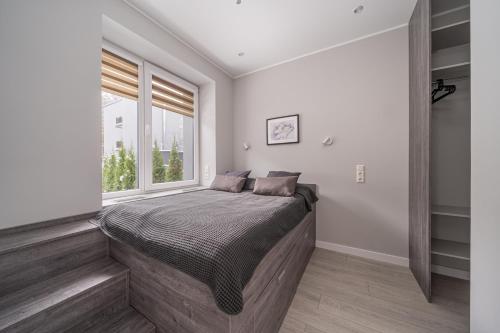 une chambre avec un lit et une fenêtre dans l'établissement Dzintaru Beachside 1BR Apartment With Courtyard View, Walk to Nature & Sea, à Jurmala