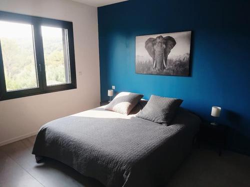 une chambre bleue avec une photo d'éléphant sur le mur dans l'établissement Villa Cassis Vue mer et vignes, à Cassis