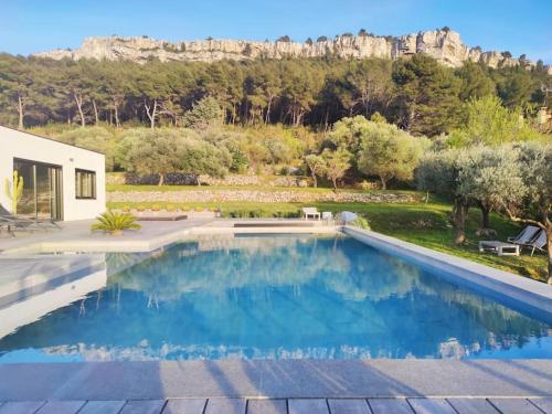 une piscine dans une arrière-cour avec une montagne en arrière-plan dans l'établissement Villa Cassis Vue mer et vignes, à Cassis