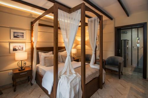 a bedroom with a four poster bed with curtains at Bellapais Gardens in Kérynia