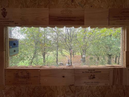 a window in a house with a view of trees at Le Cabanon in Dangeau
