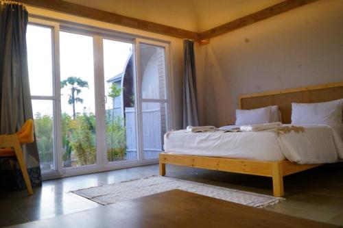 een slaapkamer met een bed en een groot raam bij V Hotels and Resorts in Chīrāla