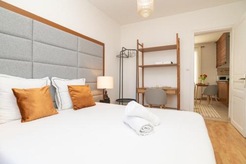 ein Schlafzimmer mit einem großen weißen Bett mit orangefarbenen Kissen in der Unterkunft The Exclusive Stay - Duke Housing in Vitry-sur-Seine