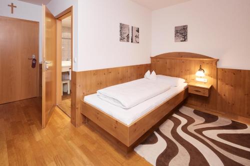 Schlafzimmer mit einem Bett mit einem Kopfteil aus Holz in der Unterkunft Hotel Zu den Drei Kronen in Donauwörth