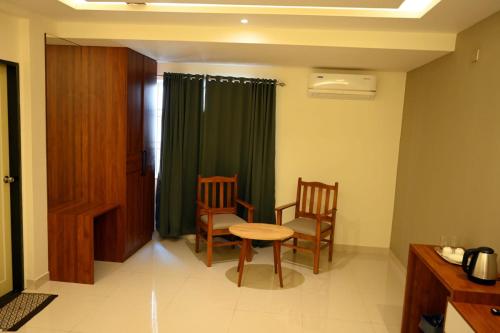 um quarto com uma mesa e duas cadeiras e uma mesa em Dwaraka Residency em Mangalore