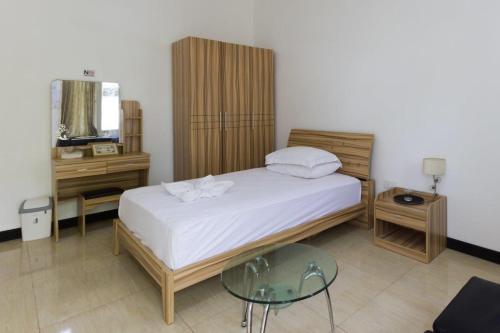Schlafzimmer mit einem Bett und einem Glastisch in der Unterkunft Surf Trip Maldives in Thulusdhoo