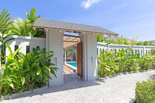 a villa with a swimming pool and a white fence at Private Resort Boutique Pool Villa Dalaa 5 , near Kamala Beach in Kamala Beach