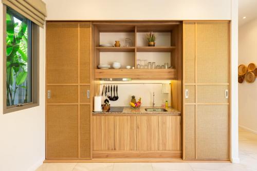 a kitchen with wooden cabinets and a sink at Private Resort Boutique Pool Villa Dalaa 5 , near Kamala Beach in Kamala Beach
