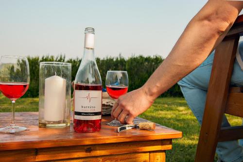 a person reaching for a bottle of wine and two glasses at Tenuta il Poggetto in Radda in Chianti