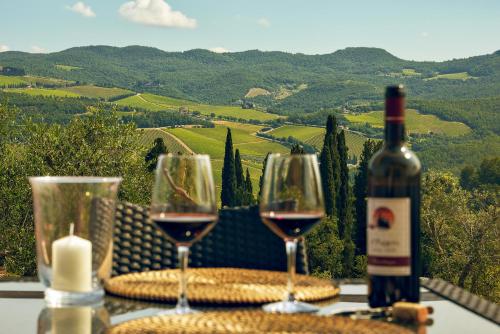 two glasses of wine sitting on a table with a view at Tenuta il Poggetto in Radda in Chianti