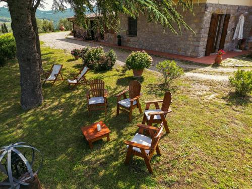 een groep stoelen en tafels in een tuin bij Tenuta il Poggetto in Radda in Chianti