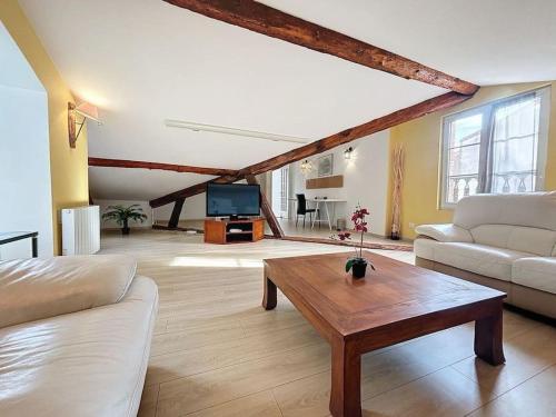 un salon avec un canapé et une table basse dans l'établissement Le chalet des Carmes - Charmant T4 Hypercentre, à Toulouse