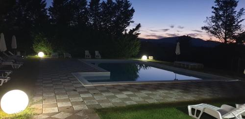 een zwembad in een tuin 's nachts bij Country House Il Vecchio Frantoio in Monteleone dʼOrvieto