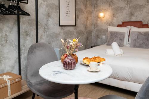 a table with a plate of croissants and a bed at The New Bliss - Duke Housing in Vitry-sur-Seine