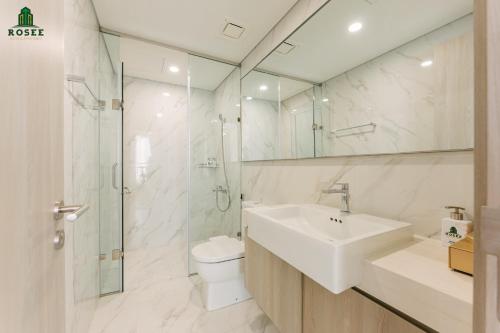 La salle de bains est pourvue d'un lavabo, de toilettes et d'une douche. dans l'établissement Rosee House - Luxury apartment in Vinhomes Smart City, à Nam Tu Liem
