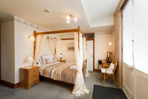 um quarto com uma cama de dossel e uma cadeira em Baldwin House em Stourport