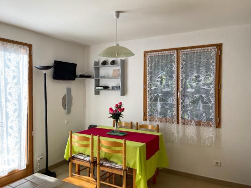 une salle à manger avec une table et un vase de fleurs. dans l'établissement Mini villa Erbalunga, Santa Giulia, à Porto-Vecchio