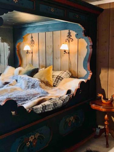 a bedroom with a large bed with two lamps on it at Eventyrlig Tømmerhytte på Gårdstun in Vinstra