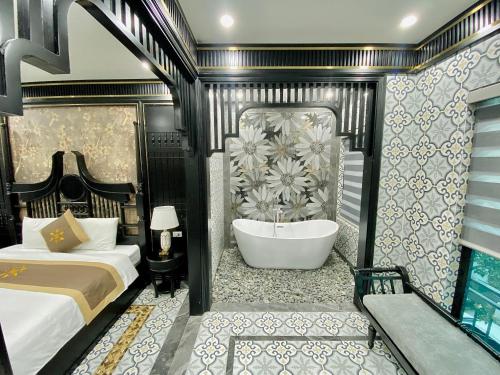 a bedroom with a tub and a bed and a bath room at Bao Ngoc hotel Pháp Vân in Hanoi