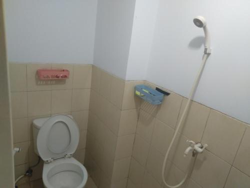 a bathroom with a toilet and a shower at Urbantown Serpong in Dukuh