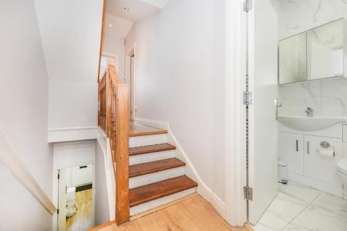 - un escalier dans une salle de bains pourvue de toilettes et d'un lavabo dans l'établissement Spacious apartment near Hammersmith staion, à Londres