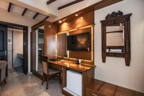 a room with a desk with a tv and a mirror at Bellapais Gardens in Kérynia