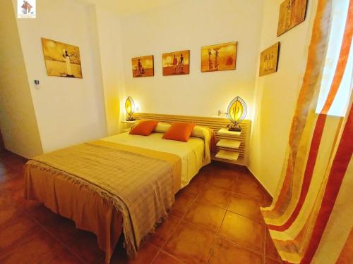 ein Schlafzimmer mit einem Bett und zwei Lampen an der Wand in der Unterkunft El Mirador de Garrucha in Garrucha