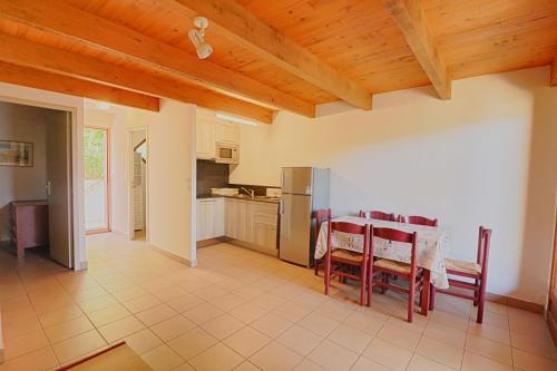 une cuisine et une salle à manger avec une table et des chaises dans l'établissement Appartement n4 rez de jardin LA LISCIA, à Calcatoggio