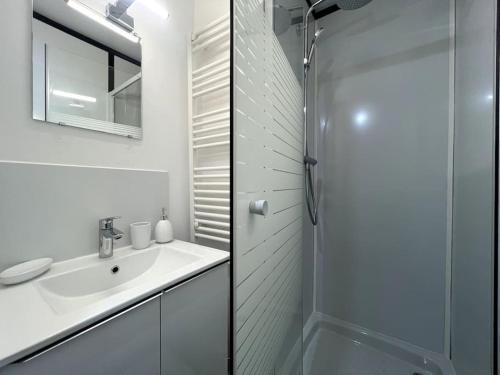 bagno bianco con lavandino e doccia di Écrin Urbain Raincy - Parking a Le Raincy