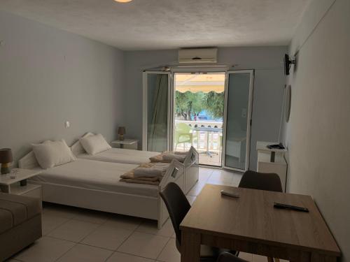 sypialnia z łóżkiem i stołem oraz balkonem w obiekcie Elia Beach Apartments Vrachos w mieście Loutsa