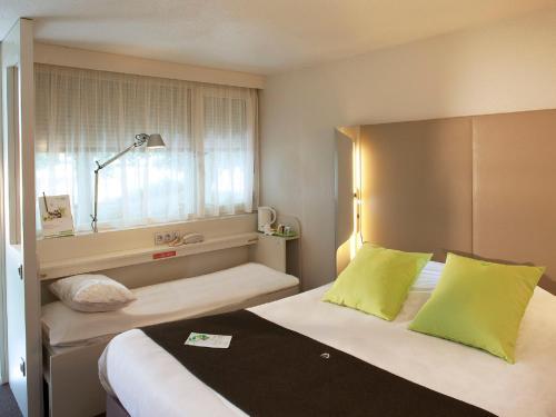 Cette chambre comprend 2 lits et une fenêtre. dans l'établissement Campanile Clermont-Ferrand ~ Riom, à Riom