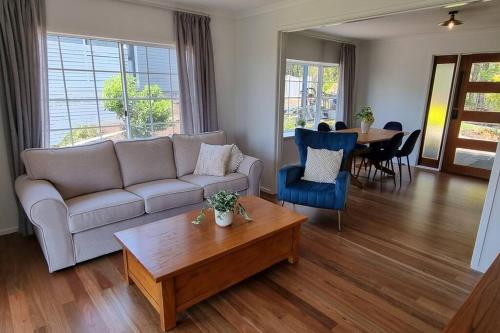a living room with a couch and a table at Serenity Cottage Retreat in Woombye