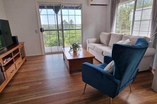 a living room with a couch and a table at Serenity Cottage Retreat in Woombye