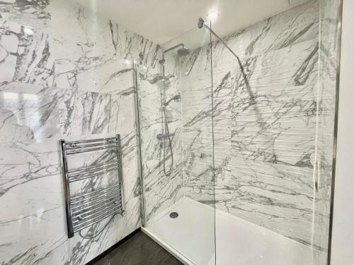 a bathroom with a shower and a marble wall at Jaurès Home by Welcome to Cannes in Cannes