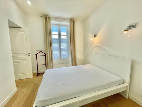 a white bed in a room with a window at Jaurès Home by Welcome to Cannes in Cannes