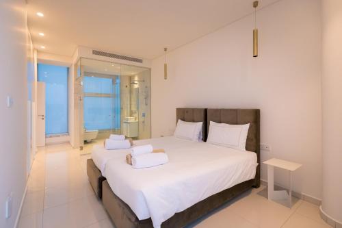 a bedroom with a large bed with white sheets and pillows at Seaview Luxury Villa Jacuzzi & Pool! 2 Min Beach in Protaras