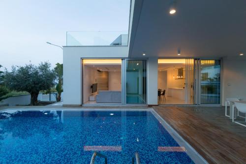 a swimming pool in front of a house at Seaview Luxury Villa Jacuzzi & Pool! 2 Min Beach in Protaras