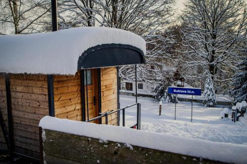 a snow covered building with a blue street sign at VAGONBublava in Bublava