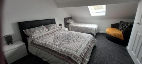 1 dormitorio con 1 cama y 1 silla en The Old Post Office Apartment, en Adlington