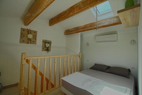 ein Schlafzimmer mit einem Bett und einem Kinderbett aus Holz in der Unterkunft Studio Le Prunelli PORTICCIO in Porticcio