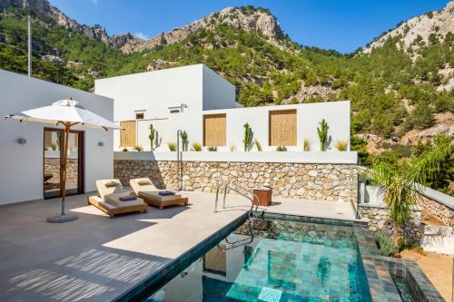 Villa con piscina y montañas de fondo en MerTelia Luxury Villas, en Kyra Panagia